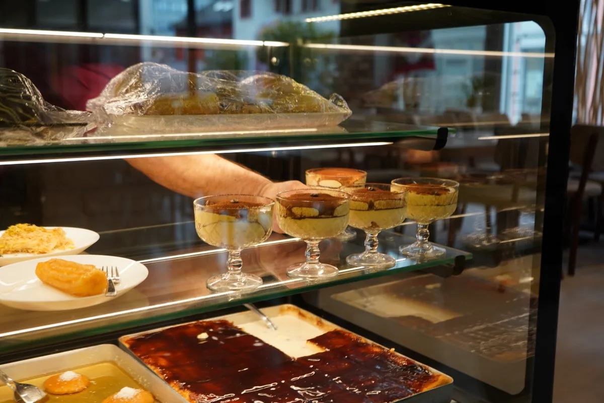 Eine Desserttheke mit Tiramisu und Schälchen.
